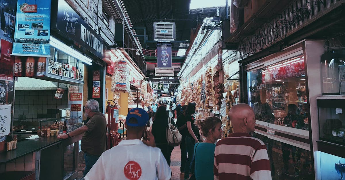 Vibrant indoor market scene with people shopping and browsing various stalls.