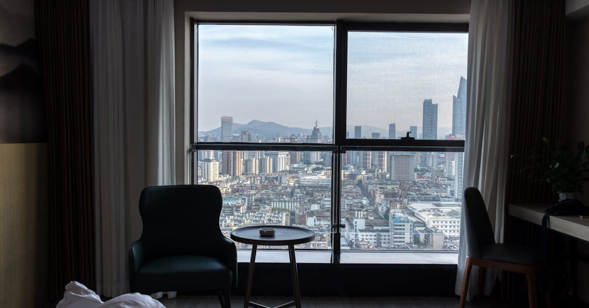 A stunning view of the city skyline from a cozy hotel room, showcasing urban architecture.