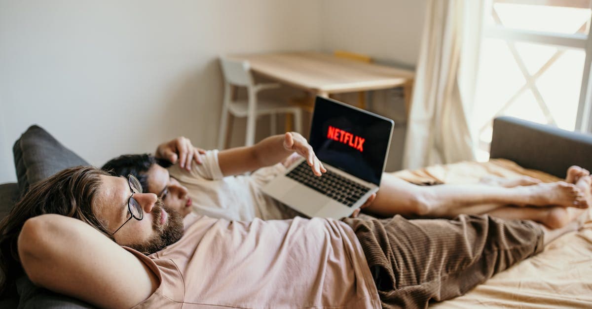 A couple lounging on bed watching Netflix, creating a cozy indoor atmosphere.