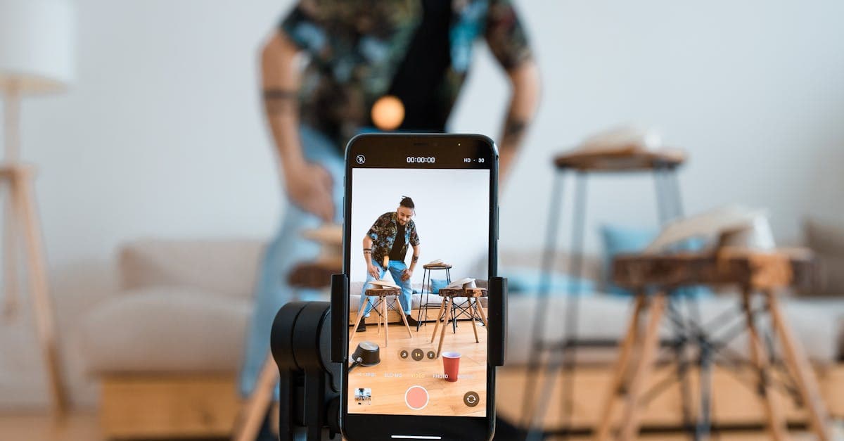 Man recording video content with smartphone on a tripod in a cozy living room.