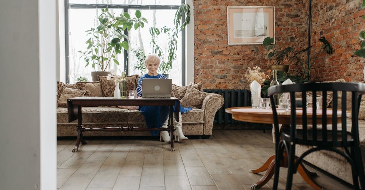 Elegant home office with elderly woman working on a laptop, surrounded by stylish interior design.