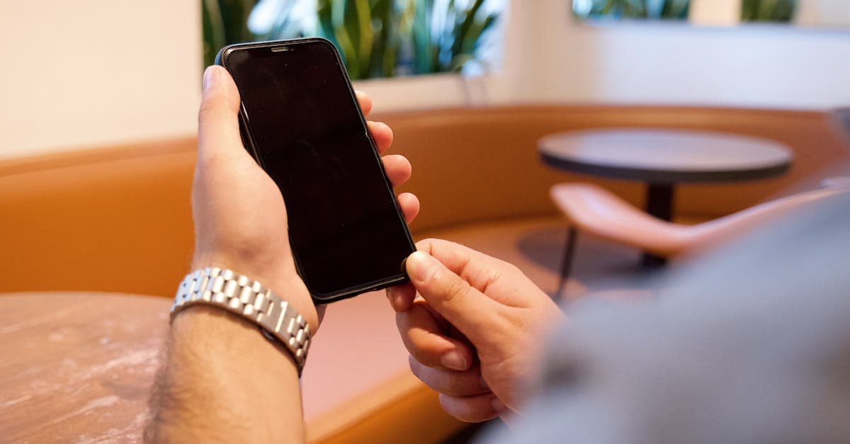 Close-up of a person using a smartphone in a stylish cafe setting.