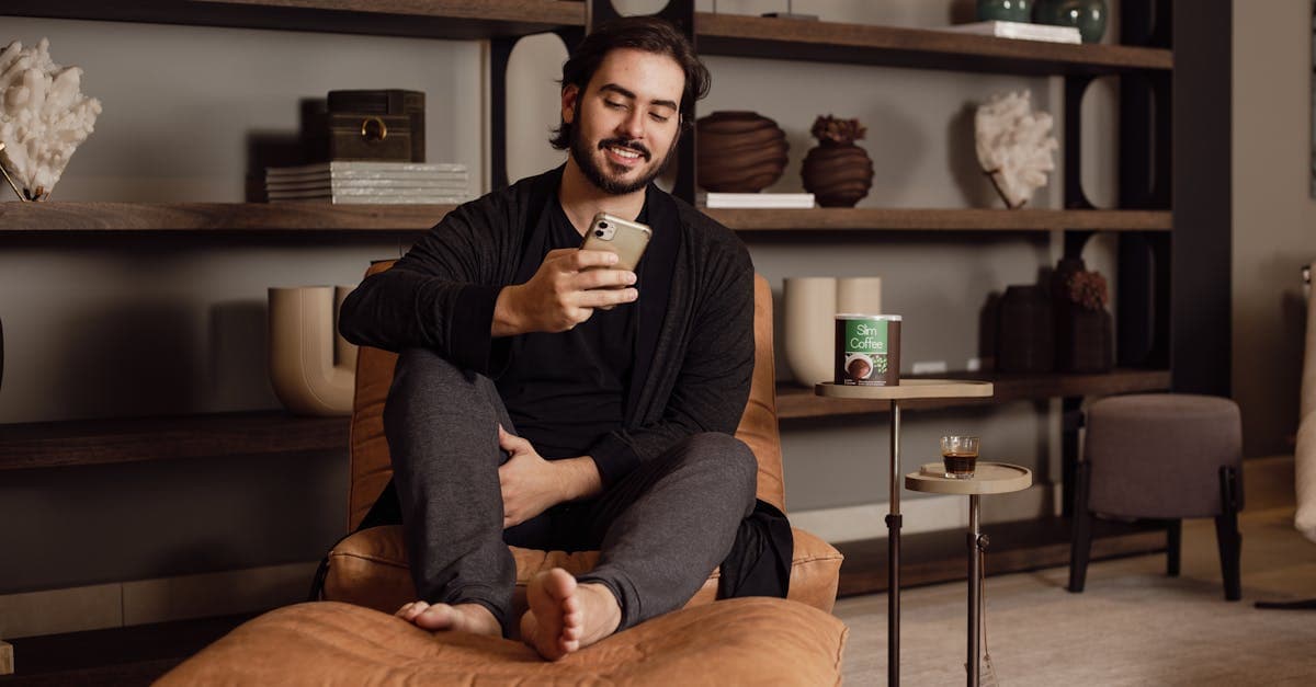 Man sitting comfortably on a chair, enjoying a moment of relaxation using a phone in a stylish living room.