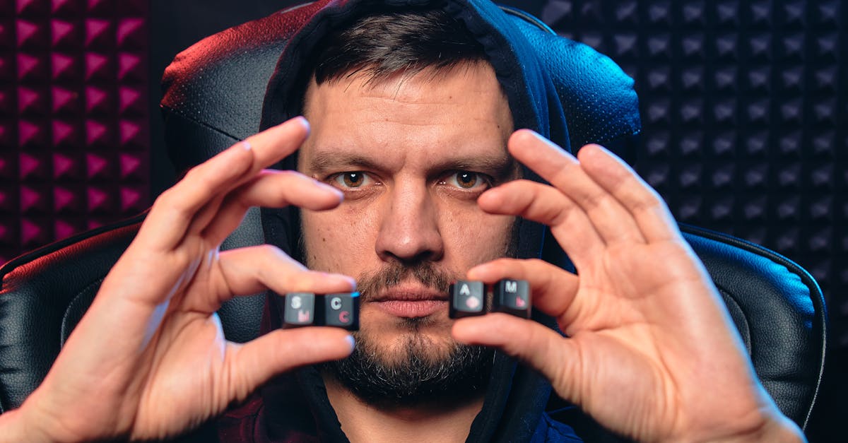 Man in hoodie holding alphabet keys spelling 'SCAM', symbolizing cybersecurity threat.